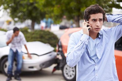 A man on the phone after a car accident.