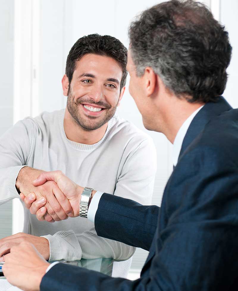 personal injury lawyer shaking hands with a happy male client