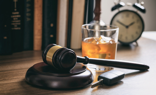 bebida alcoholica en un escritorio al lado de el martillo de justicia