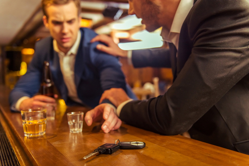 Un hombre en un bar tratando de impedir que su amigo tome las llaves de auto